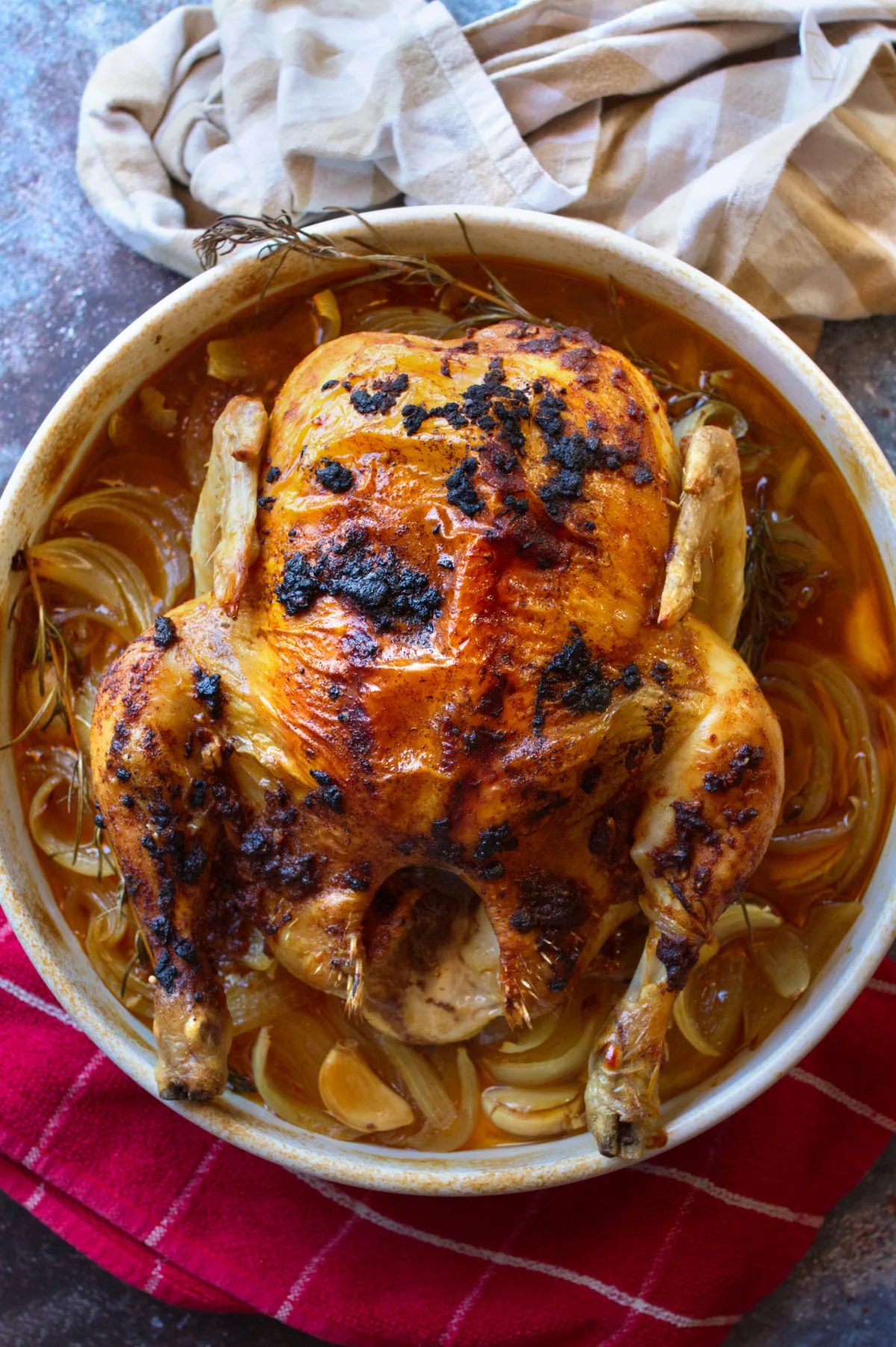 A Spanish roast chicken with a smoked paprika rub sits cooked in a large dish.