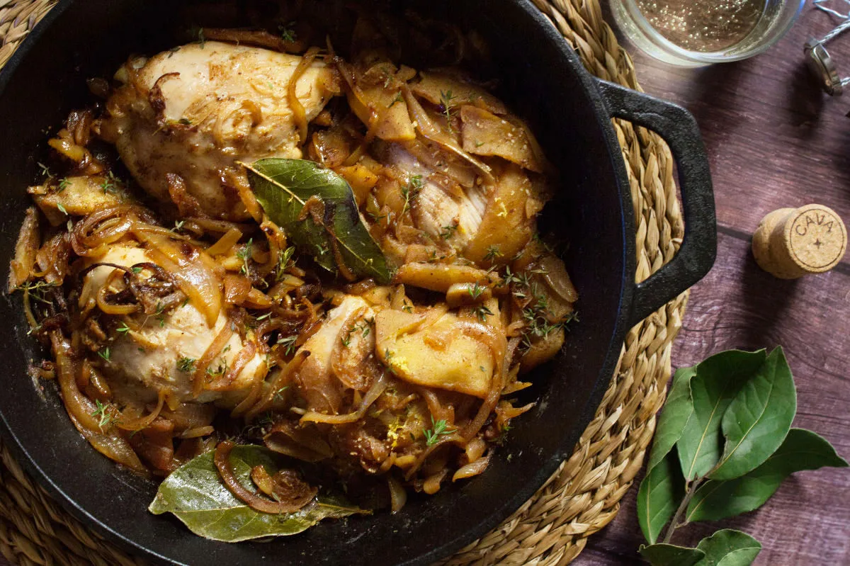 A large pot of one pot chicken thighs in cava and caramelized apples.