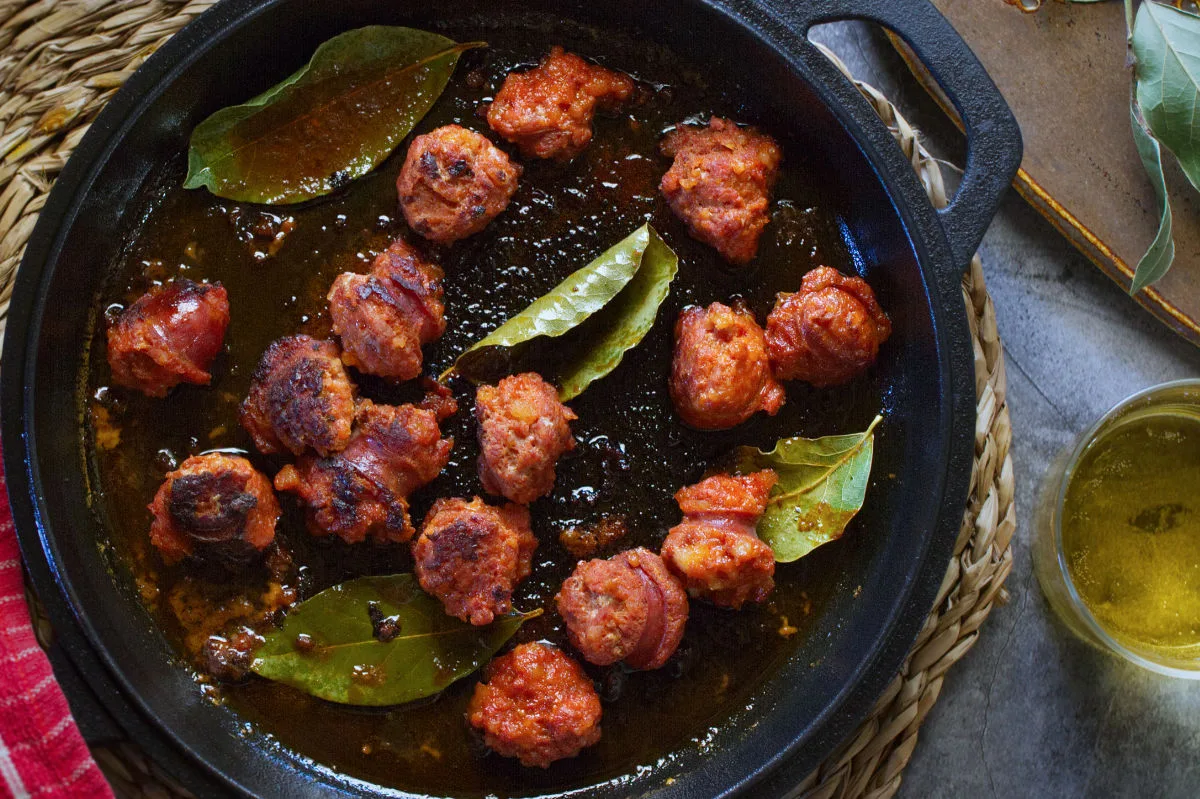 a pan of chorizo cooked in cider. 