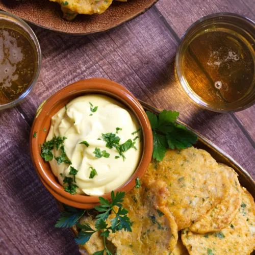 A tapas serving of Spanish cod fritters sits beside some homemade aioli.