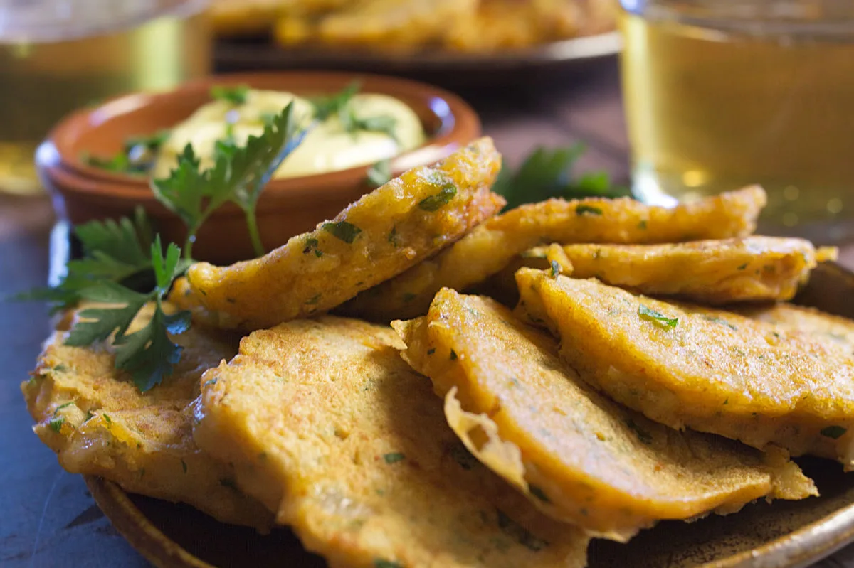 A tapas serving of Spanish cod fritters sits beside some homemade aioli.